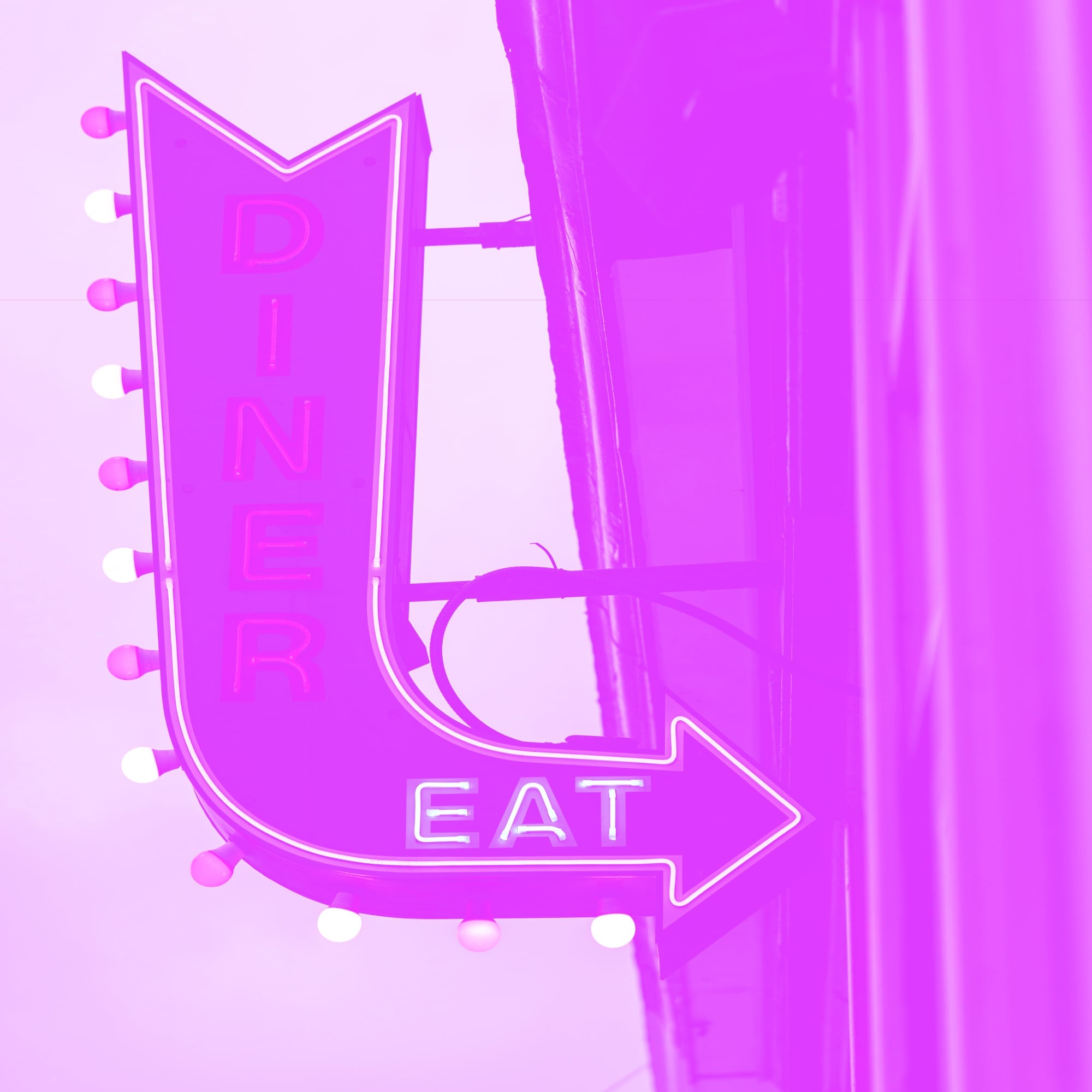 vintage illuminated dinner eat neon arrow sign on building exterior pink purple