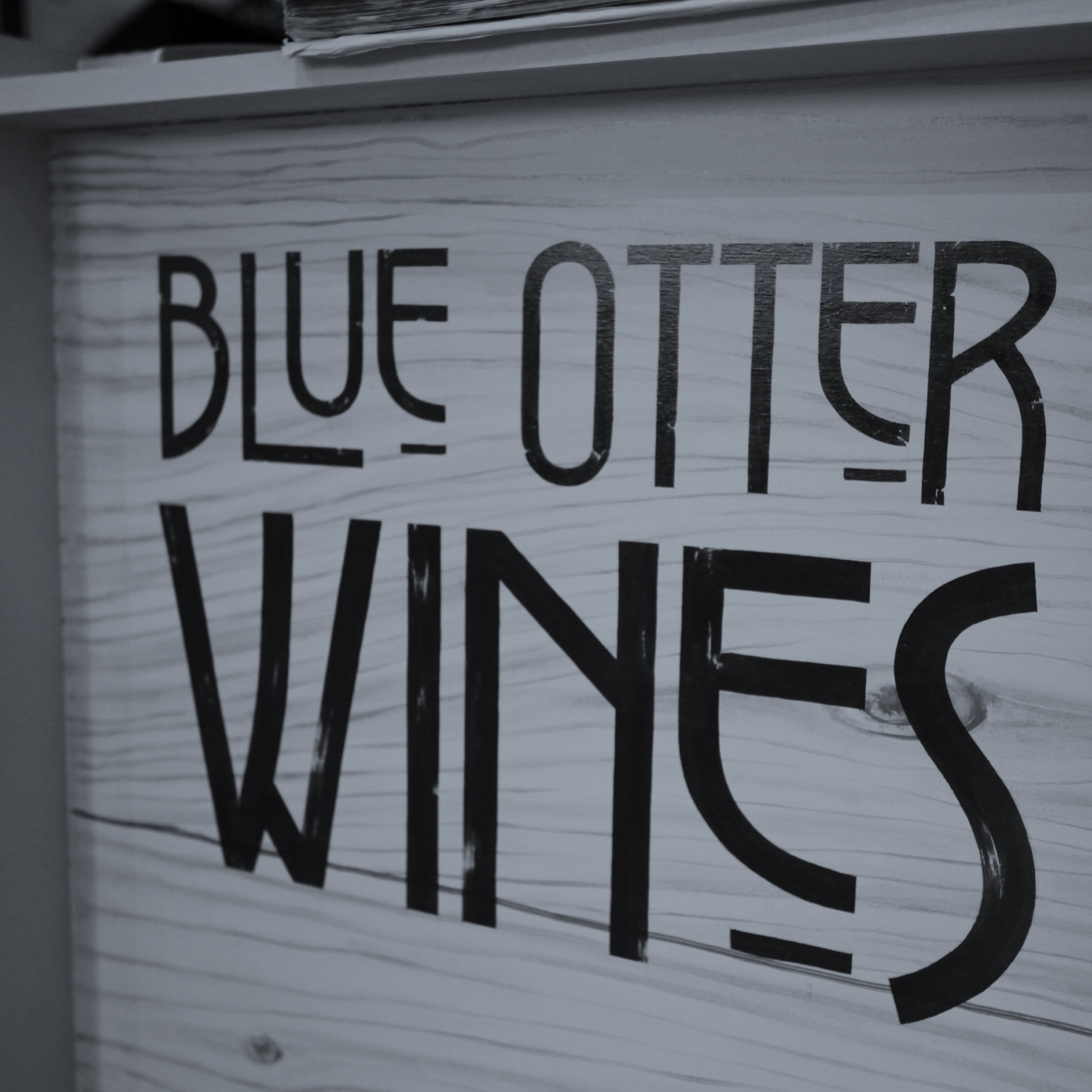 Close-up of Blue Otter Wines lettering on a wooden sign