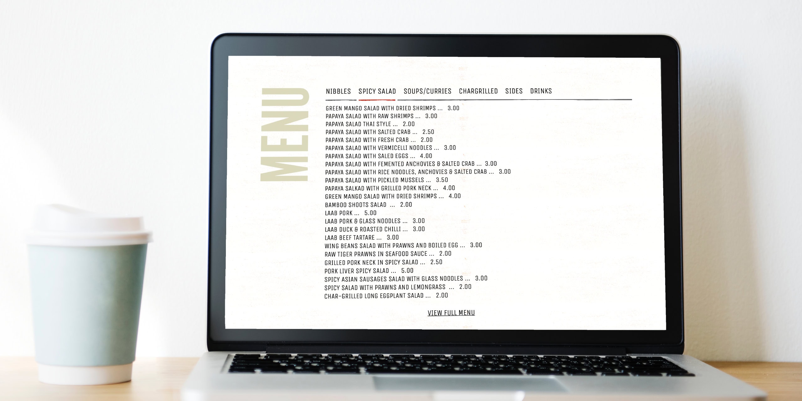 Lao Café menu page shown on a laptop screen with a takeaway coffee on the desk