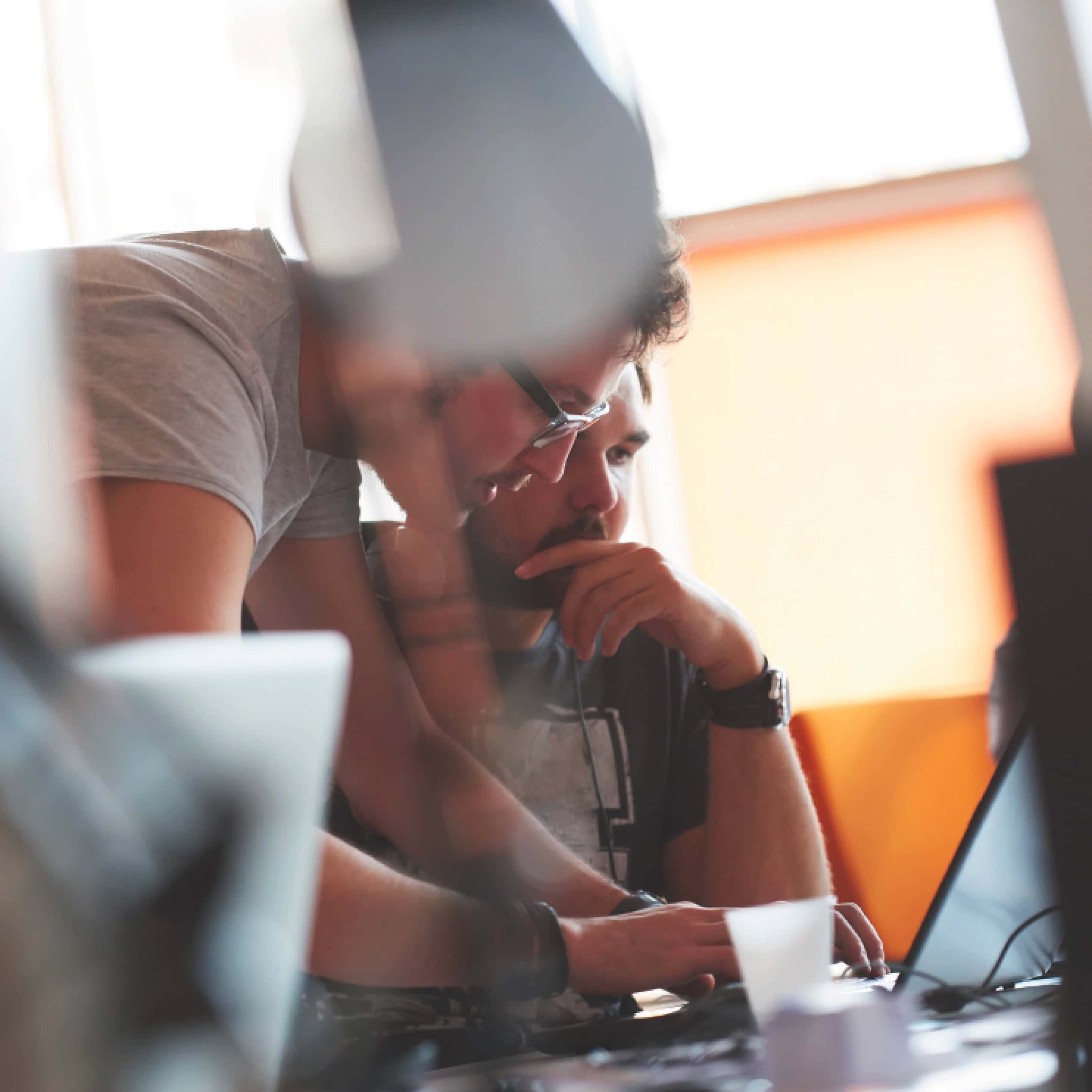 Two colleagues collaborating at a laptop during a working session
