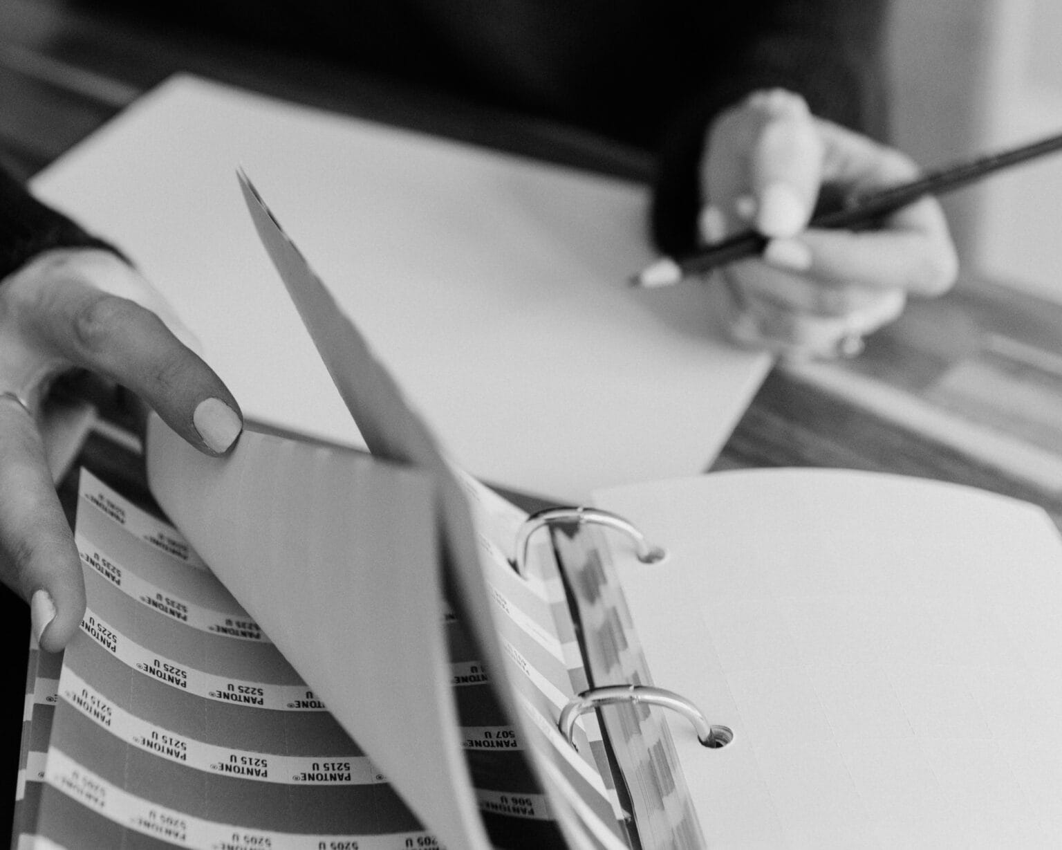 Designer referencing Pantone colour swatches