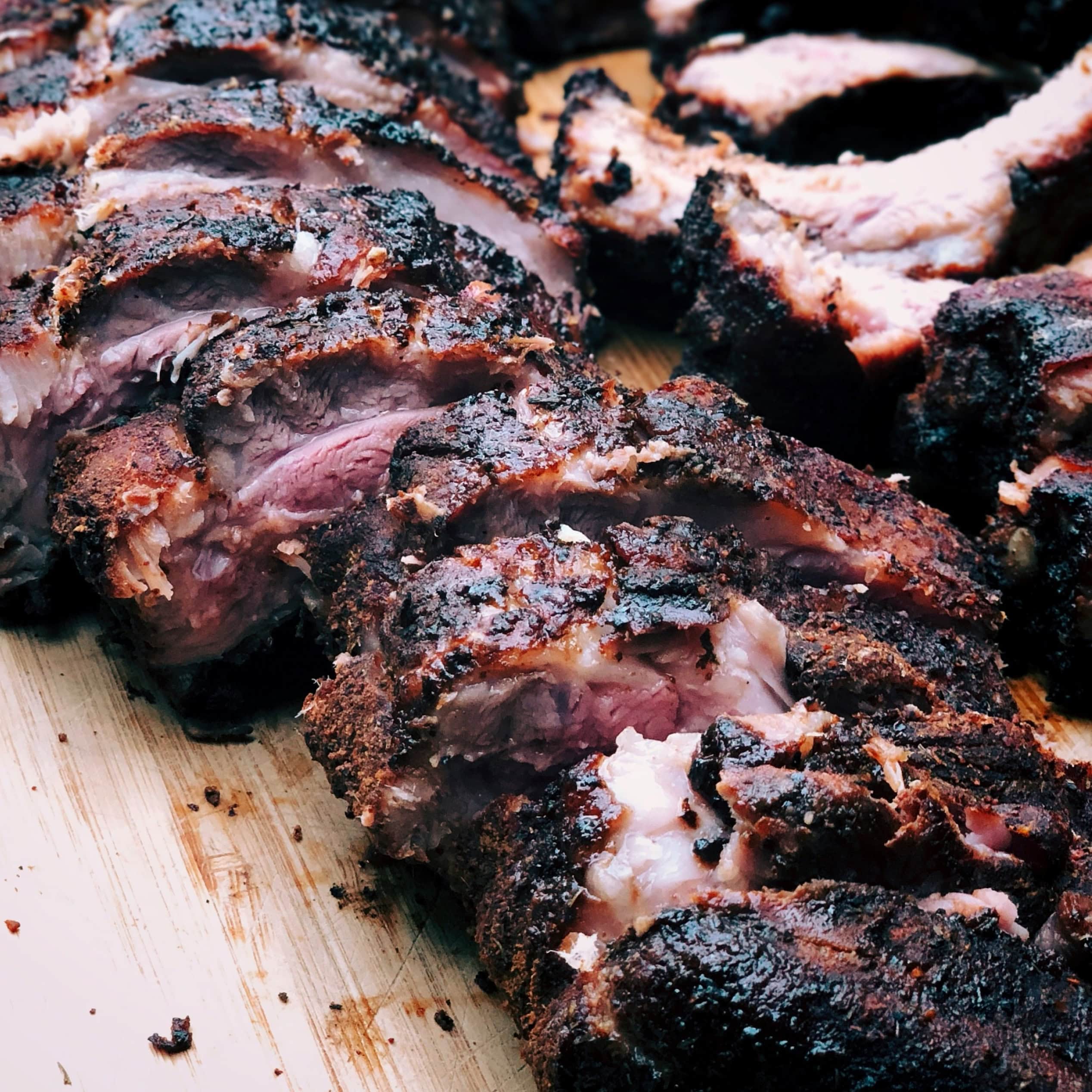 Close-up of smoked BBQ meat sliced on a wooden board