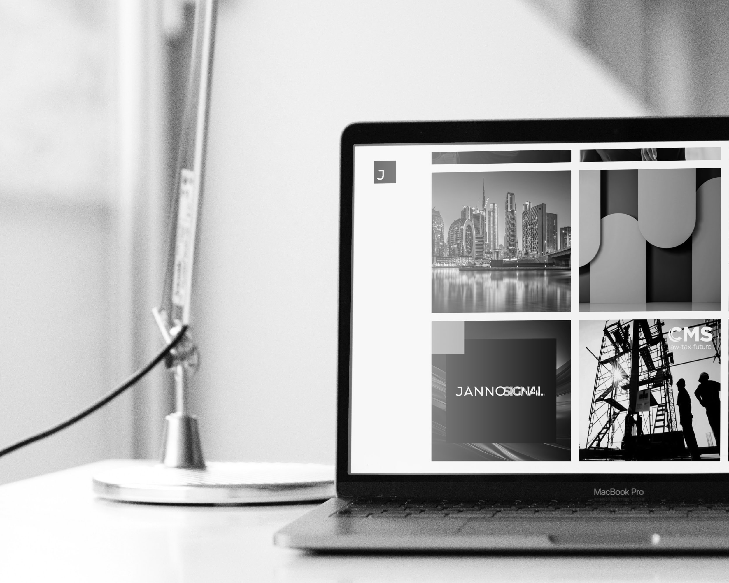 Laptop on a desk displaying a portfolio grid of project thumbnails on a website.